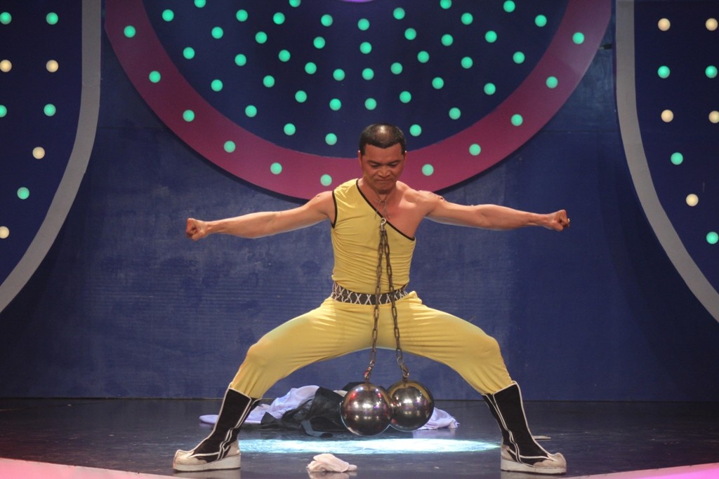 Chi chít nhửng vết thương trên cổ của siêu nhân này đã khiến cho 2 đội chơi không thể giữ bình tĩnh. Để thực hiện động tác này, một chiếc móc sắt phải luồn qua phần da thịt trước cổ để làm điểm tựa cho việc móc các vật nặng vào sau đó.