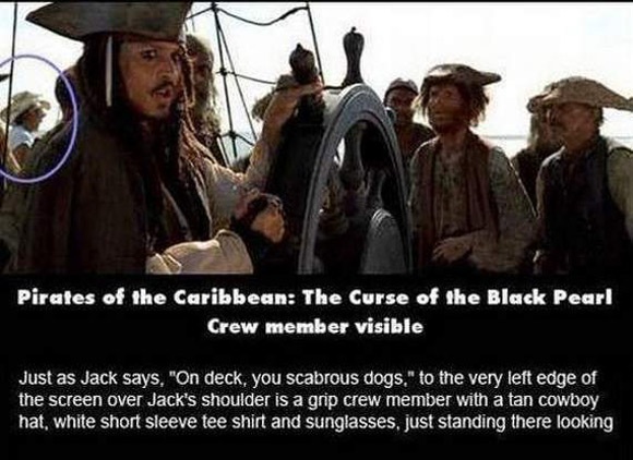 Một nhân viên đoàn phim mặc áo trắng, đội mũ cao bồi và đứng giữa đám thủy thủ trên con tàu của Jack Sparrow trong Pirates of the Caribbean: The Curse of the Black Pearl.