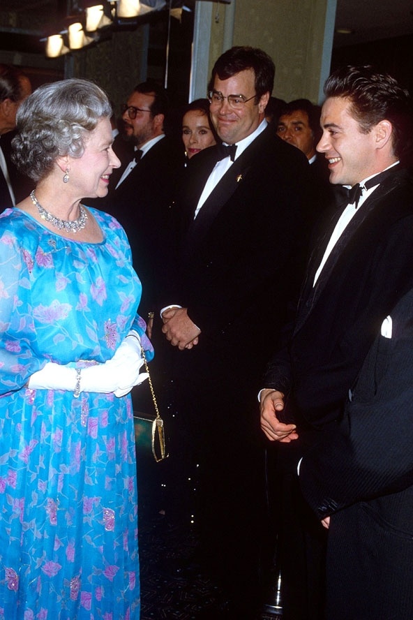 Khi gặp Dan Aykroyd và Robert Downey Jr tại lễ kỷ niệm của vua hề Chaplin năm 1992, nữ hoàng đẹp tuyệt vời với chiếc váy dài xếp ly xanh da trời, găng tay trắng và chuỗi vòng kim cương quý gia.