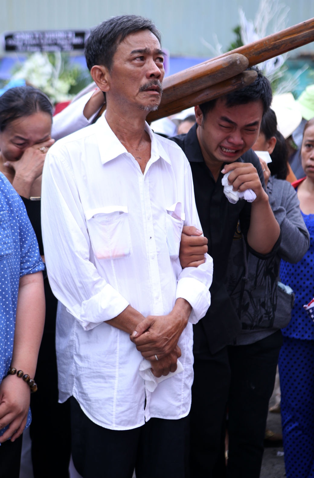 Gương mặt của người cha khắc khổ cố kháng cự lại những giọt nước mắt trong lúc đưa tiễn cậu con trai duy nhất về với lòng đất mẹ.