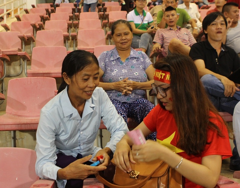 Mẹ Công Phượng vui vẻ trò chuyện cùng một cổ động viên trên khán đài sân Mỹ Đình.