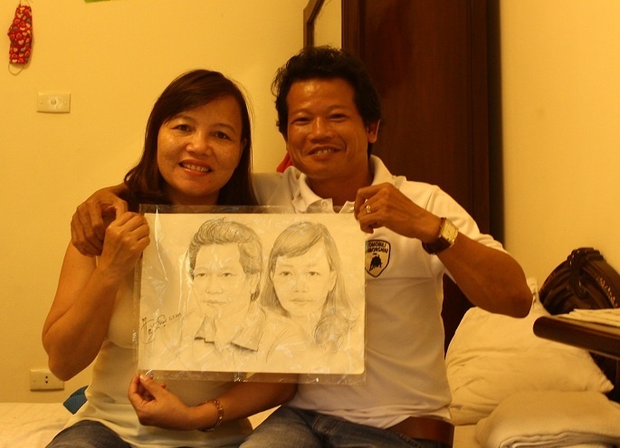 Bố mẹ Đông Triều và kỷ niệm bức vẽ chân dung được thực hiện ở Hồ Gươm, trong những ngày ra Hà Nội cổ vũ con trai thi đấu giải U19 ĐNA mở rông. Ảnh: Hoàng Minh
