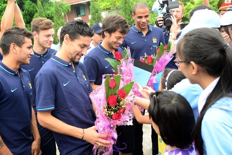 Cầu thủ Man City nhận hoa từ các em nhỏ làng trẻ em SOS Hà Nội.