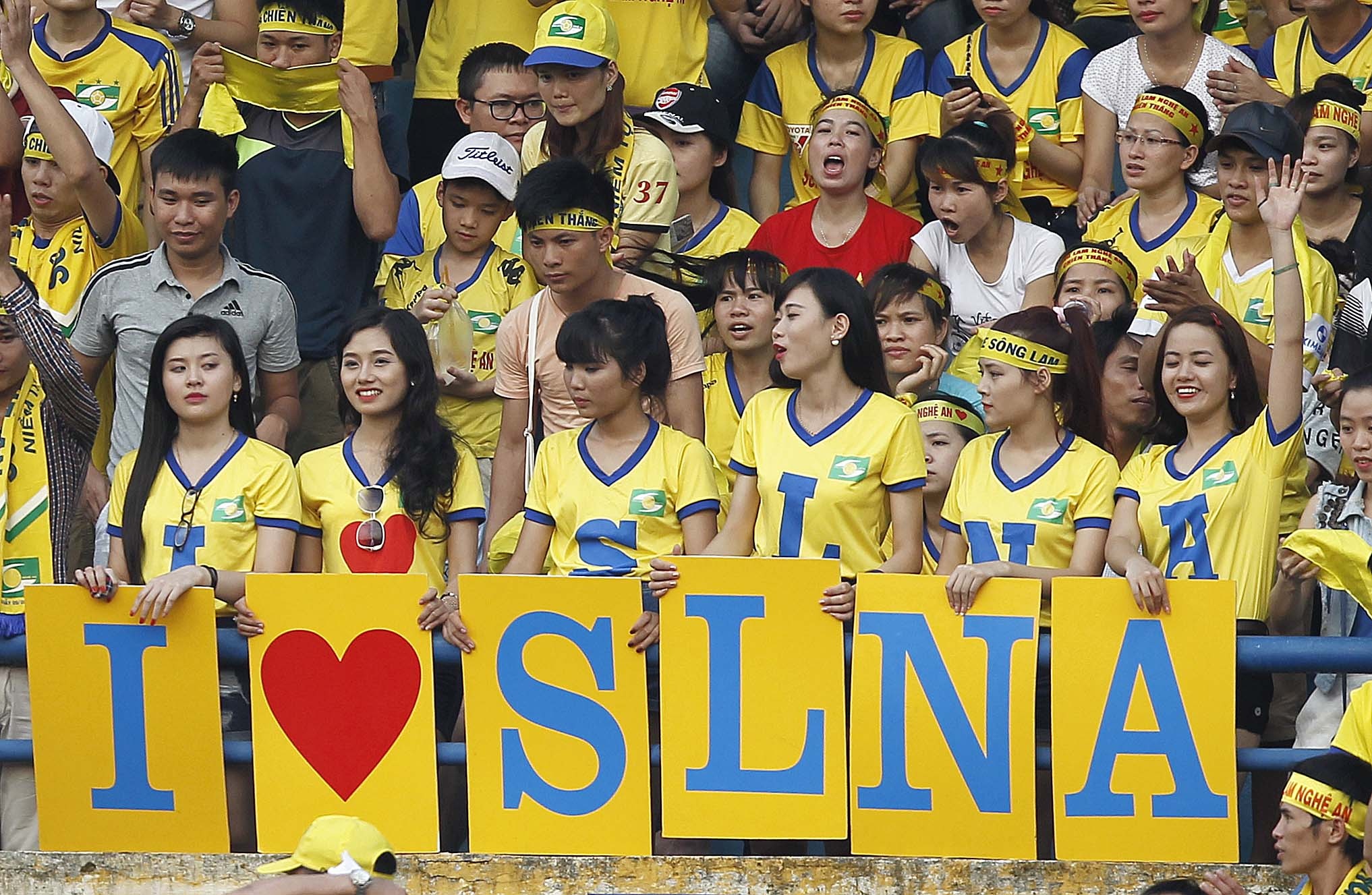 Sáu fan nữ xinh xắn được lựa chọn từ hàng trăm CĐV vinh dự mặc áo có chữ viết tắt của thông điệp