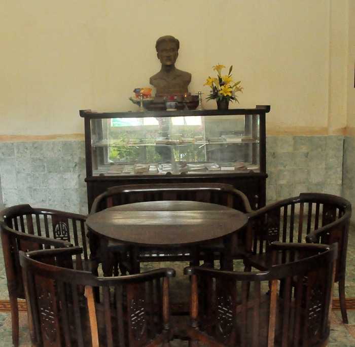 Trong phòng khách là bộ bàn ghế gỗ với gian thờ nhỏ.