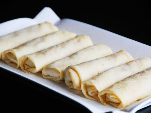 Trải một miếng bánh tráng pía ra thớt sạch, cho 1 muỗng nhân thịt cua, rau củ vào cuốn thành cuốn dài. Làm lần lượt đến hết nguyên liệu.