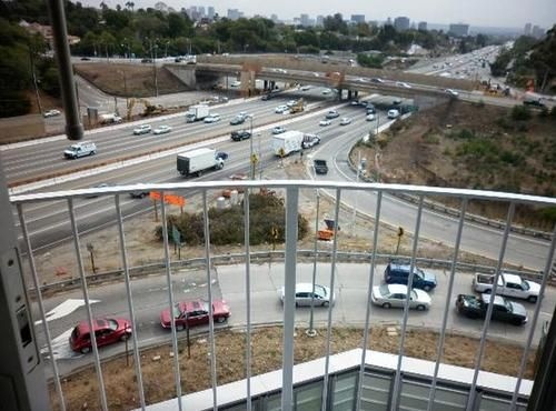 2. Los Angeles, Khách sạn tuyệt tác cuộc sống tươi đẹp - Âm thanh và phong cảnh Los Angeles là đây: Đây là một khách sạn sang trọng, tuy tọa tại vị trí đắc địa là ngã tư Santa Monica và Beverly Hills, nhưng nhìn từ phòng khách sạn, view thật chẳng ra làm sao, đã thế lại còn ngay sát một trong những đường cao tốc tấp nập nhất thế giới - đường cao tốc 405, nên cùng với view trên là hình ảnh của xe nối tiếp xe, đấy là chưa kể tiếng ồn.  