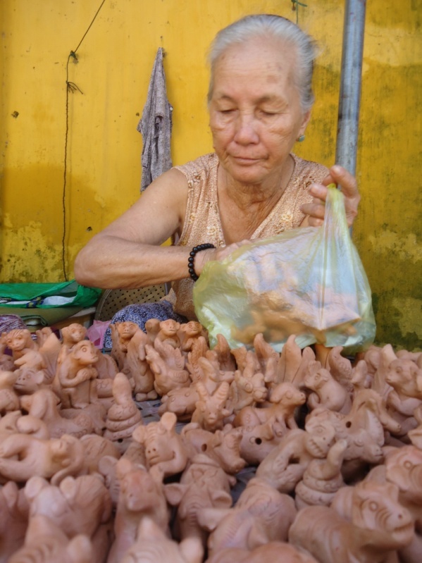 Bà cụ bán tò he. Tôi vẫn hay nghĩ có phải vì phố cổ nên người già ở đây khá đông, họ điều làm việc. Bạn sẽ bắt gặp các bà cụ tóc bạc phơ, mặc bộ đồ bà ba ngồi bán những  con tò he bằng đất sét. Tất nhiên họ sẽ rất vui nếu ai đó mua hàng của mình.