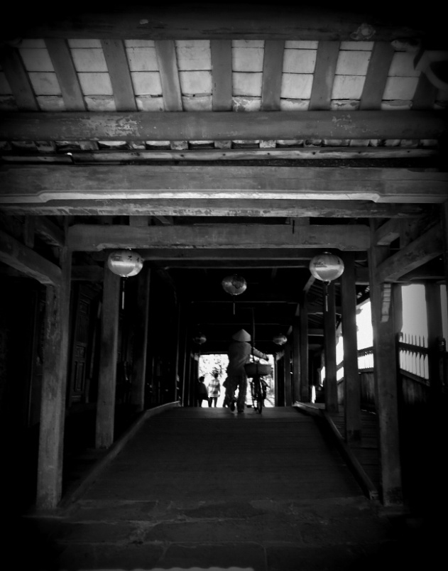 Mưu sinh là tên bức ảnh này. Sự thâm trầm, cổ kính của Chùa Cầu đối lập với sự nhỏ nhoi, khắc khổ của cuộc sống. Nhưng người và chiếc xe đạp nhỏ bé chính là nguồn sống của một gia đình.