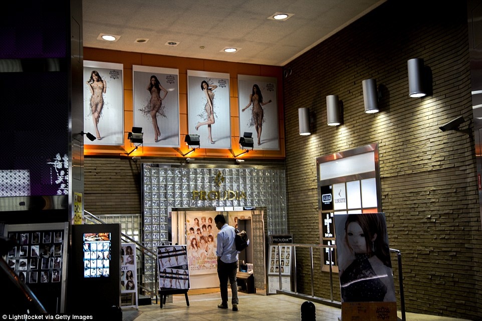 Một khách hàng tiềm năng đang đứng bên ngoài khách sạn tình yêu ở Shinjuku, Tokyo.