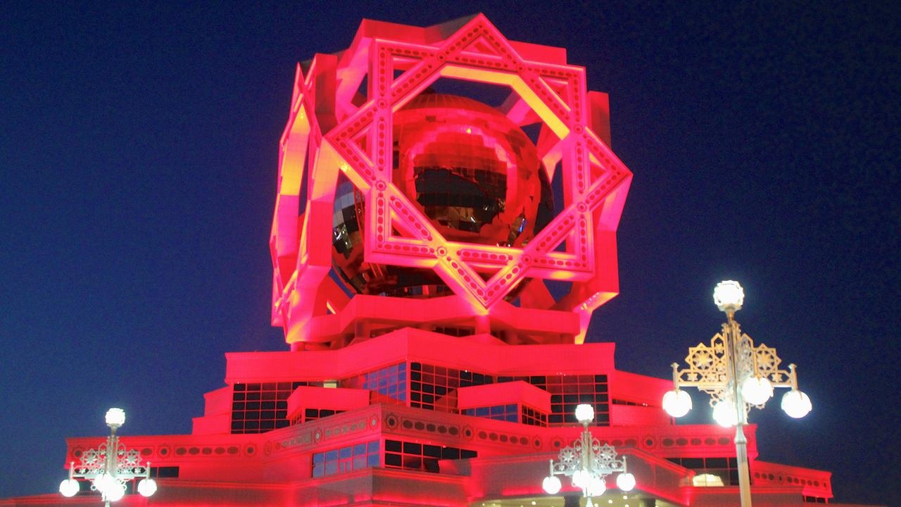 Về đêm, những tòa nhà màu trắng ở Ashgabat được thắp sáng bằng rất nhiều đèn màu và đại lộ cũng được thắp sáng. Trong hình là Cung Hôn Lễ, cứ mỗi phút vào buổi tôi, địa điểm này luôn đổi màu từ đỏ sang xanh lá cây sang xanh nước biển.