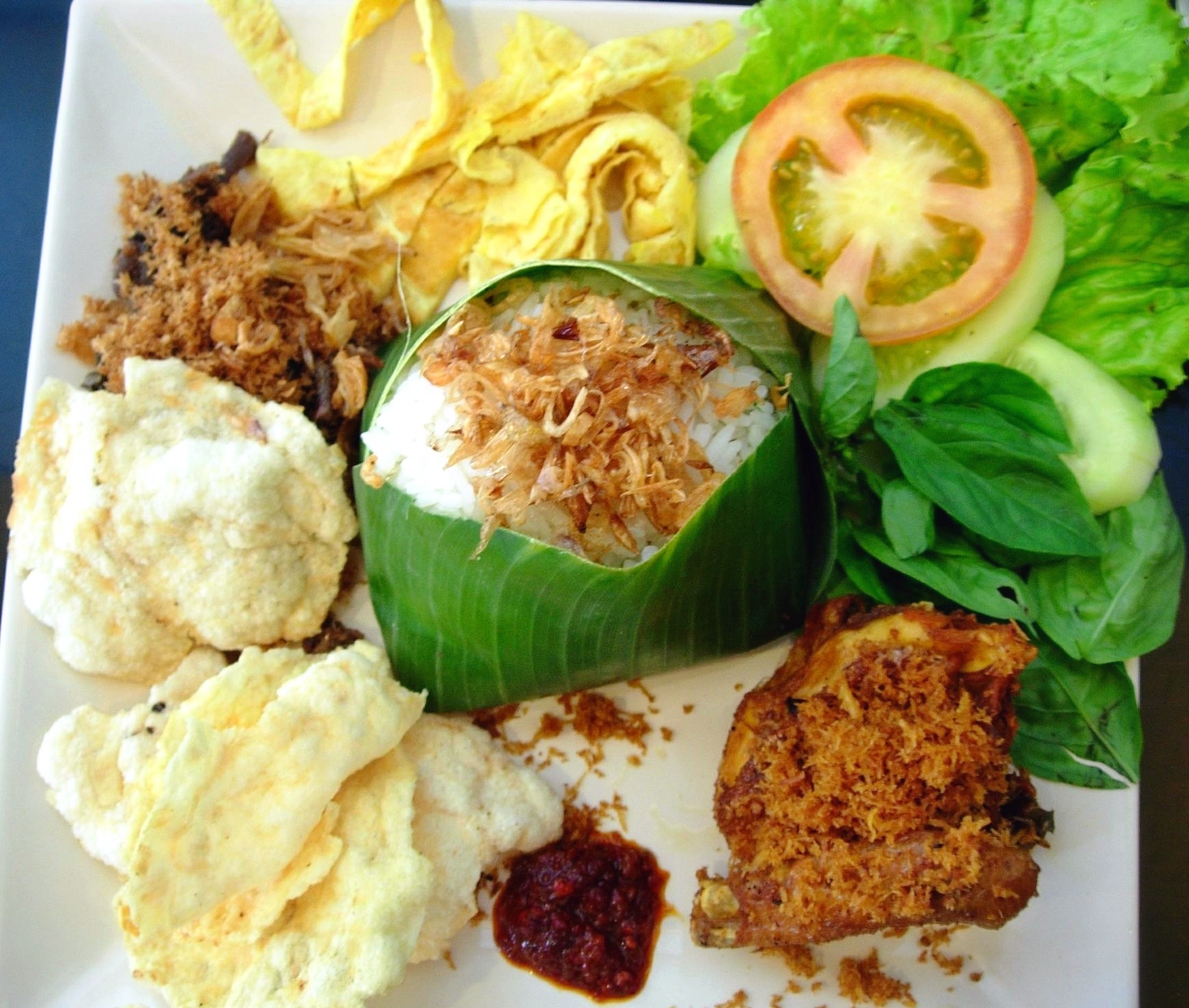 10. Nasi Uduk. Nasi Uduk hay còn gọi là cơm nước cốt dừa, tên gọi này xuất phát từ cách chế biến của món ăn. Ngoài hương thơm dậy mùi của chén cơm nấu cùng nước cốt dừa, Nasi Uduk còn mời gọi du khách với hàng loạt món phụ khác như thịt tẩm gia vị, cá, thịt gà, trứng luộc, xốt ớt và bánh quy giòn.