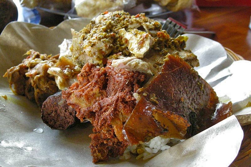 2. Babi Guiling (heo sữa quay). Nếu có dịp ghé thăm đảo Bali xinh đẹp du khách không nên quên thưởng thức món Babi Guling. Món ăn được làm từ thịt heo sữa quay và gạo. Cả hai hòa cùng trộn lẫn với một hỗn hợp các loại gia vị băm nhỏ bao gồm hẹ tây, tỏi, gừng, nghệ, hạt tiêu, rau thơm, riềng, ớt, sả… trước khi đem quay trên một ngọn lửa lớn trong vòng 5 giờ đồng hồ. Món Babi Guling thường được làm trong các dịp lễ lớn để cúng tế của người dân đảo Bali.