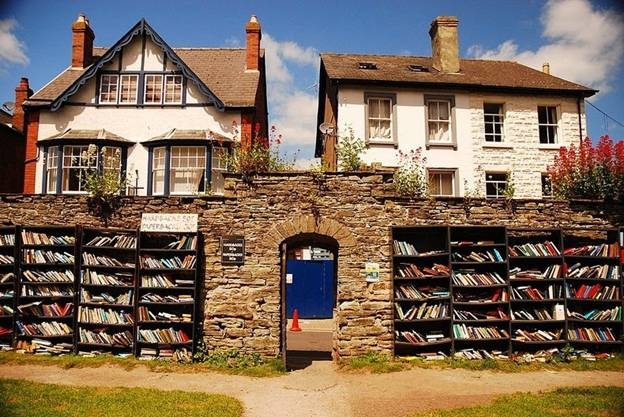 Hiệu sách Honesty Bookshop của Hay-on-Wye, thị trấn Welsh, Anh: Thường được mô tả như là “thị trấn của cuốn sách”, Hay-on-Wye thu hút một số lượng lớn những người yêu sách đến đây tìm kiếm trong hơn 40 nhà sách, chủ yếu là sách cũ.  Trong số nhiều hiệu sách, nổi tiếng và thú vị nhất là “Honesty Bookshops” – hiệu sách trung thực. Ở đó chỉ là hai kệ sach đặt ở bên tường và không có người trông coi. Mọi người đến đơn giản là chọn sách và trả tiền và một hộp thư nhỏ. Hiệu sách nằm trong phần đất của pháo đài Hay, một pháo đài có từ thế kỷ 12 năm ở trung tâm thị trấn. Không gian sách ngoài trời này bao gồm các kệ gỗ, đặt cạnh các bức tường.