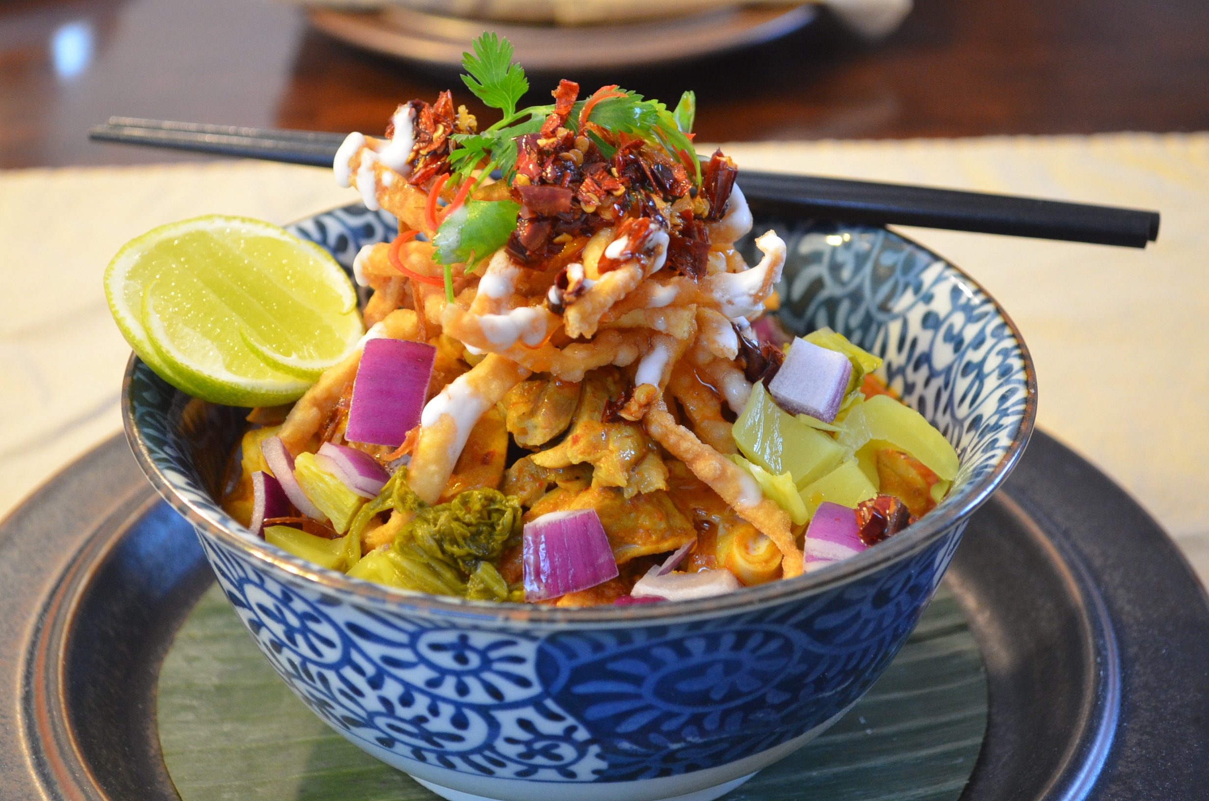 1. Khao Soi  Không gì có thể thể hiện rõ việc bạn đang ở Chiang Mai bằng cách thưởng thức món Khao Soi, món mì xào giòn với điểm nhấn là cà ri – một một ăn đặc sản của nơi đây. Món ăn truyền thống này thường được phục vụ với gà hoặc thịt bò, dùng thêm với một số gia vị khác như tương ớt, bắp cải muối, hẹ và chanh.  Món ăn được cho là nổi tiếng nhất ở miền Bắc của Thái Lan này bạn có thể tìm thấy ở mọi nơi từ những khu nghỉ mát 5 sao, tới những quán ăn bên vỉa hè, nhưng trên tất cả nó là món ăn thực sự thơm ngon và dân dã. Khi thưởng thức món ăn này bạn có thể dùng kèm với một ly bai bua bok (rau má), sẽ là cách giúp bạn giải nhiệt sau khi thưởng thức một bữa ăn nhiều gia vị. Ảnh: Southpacificengagement.com.