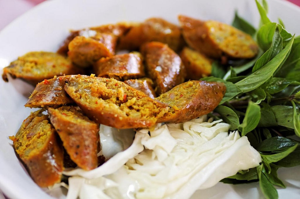 2. Sai Oua  Món Sai Oua hay còn được gọi là xúc xích Chiang Mai được làm từ thịt heo và bán ở khắp các quán ăn đường phố ở Chiang Mai. Loại xúc xích này có vị chua của chanh và vị cay đặc trưng của ớt, gừng. Đây cũng là một món rất phổ biến trên bàn ăn của người dân địa phương. Ảnh: Flickr.com.
