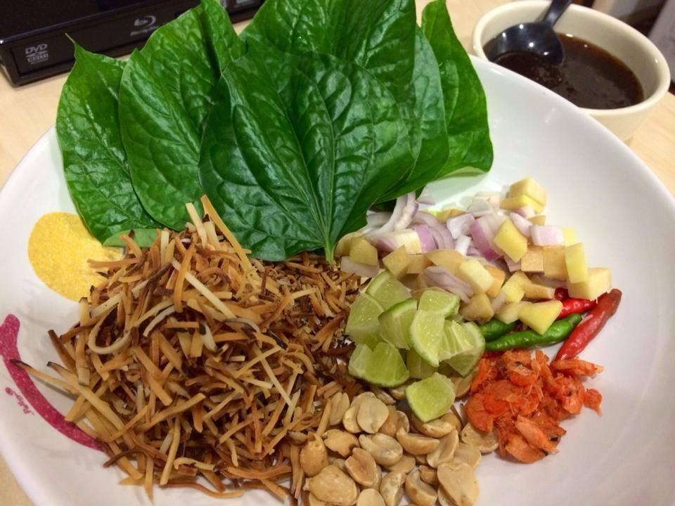 8. Miang Kham  Miang Kham là một món ăn vặt rất phổ biến trên đường phố Chiang Mai. Du khách có thể tự chọn cho mình vị chua, cay, ngọt, mặn khác nhau. Khi ăn món Miang Kham, người ăn chỉ cần lấy lá lốt và gói các nguyên liệu thích ăn như: thơm, tôm khô, đậu phộng, ớt hiểm, hành, chanh, dừa… Ngoài ra, cũng có những quán hàng rong ven đường bán Miang Kham đã được gói sẵn để du khách mua ăn cho tiện. Nước sốt chua ngọt chính là điểm nhấn cho món ăn này. Ảnh: Learnthaiwithmod.com.