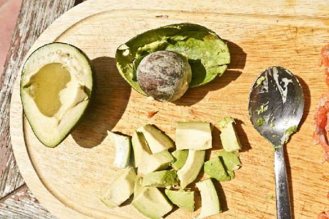 Bơ bổ đôi, lấy phần thịt cắt thành những miếng nhỏ vừa ăn.