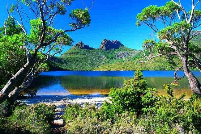 Tasmania, Austrania  Đây là bang đảo duy nhất của Úc, là hòn đảo lớn thứ 26 trên thế giới. Tasmani được biết đến như một thiên đường hoang sơ cho những người thích khám phá. Đảo Tasmania có hình trái tim với những thung lũng xanh, những thị trấn yên tĩnh và những đường bờ biển hoang sơ. Đây là một trong những hòn đảo có địa hình nhiều núi nhất thế giới. Đến đây các bạn sẽ được trải nghiệm với những trò chơi đầy mạo hiểm: Lướt sóng, chèo thuyền kayak, hành trình khám phá hồ St. Clair sâu nhất nước Úc, ngắm nhìn động vật hoang dã trong vường quốc gia Narawntapu … 