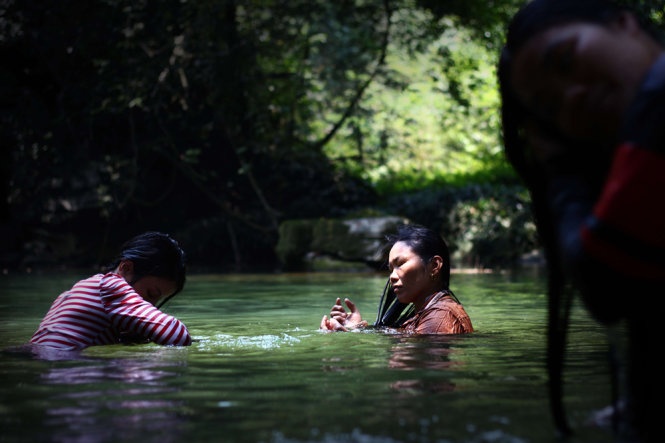 Những phụ nữ địa phương gội đầu bên dòng nước mát rượi. Ảnh: Ngọc Dương.