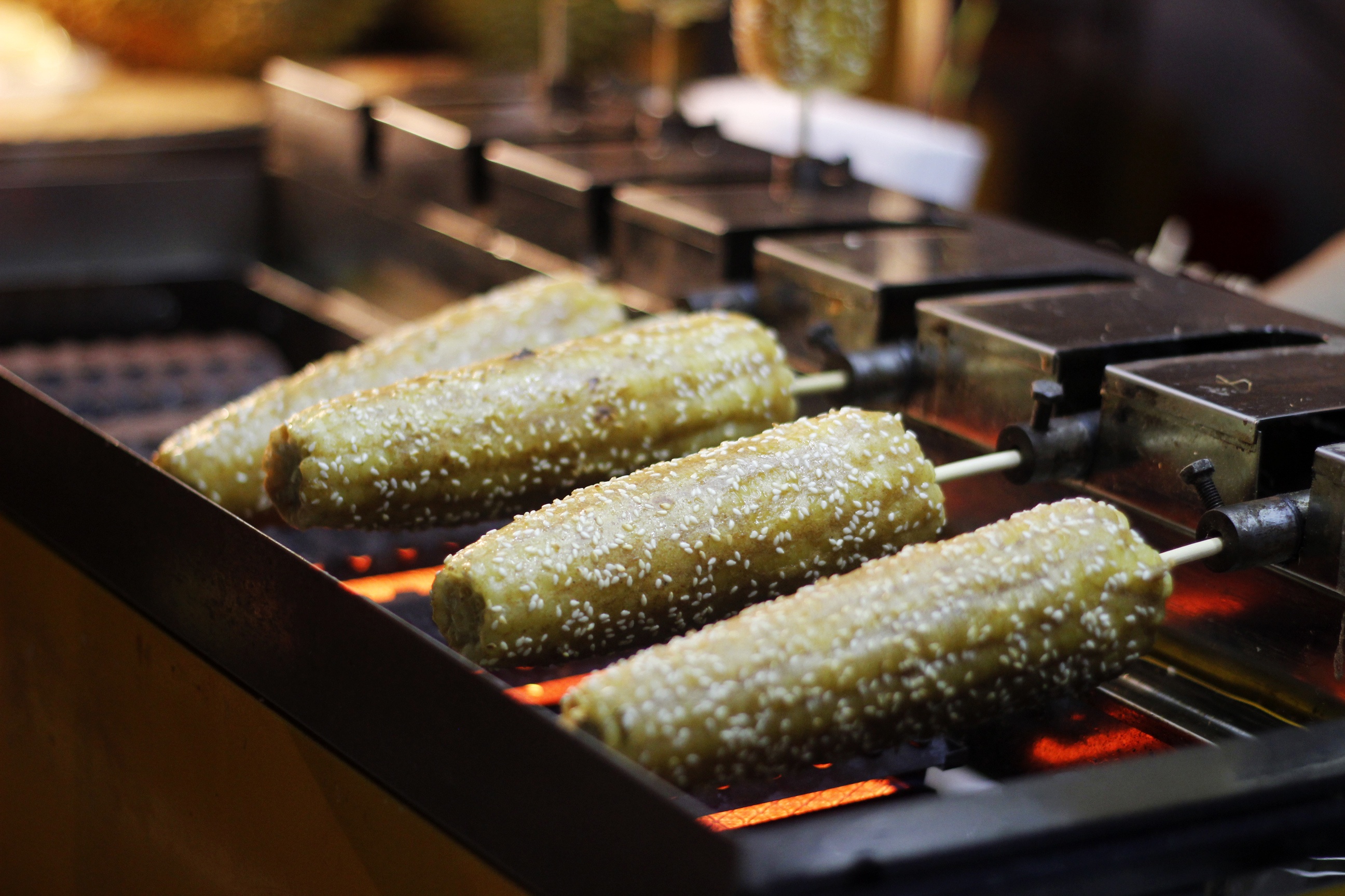 Ngô nướng được quết một lớp sốt dày và rắc vừng bên ngoài, khi ăn vẫn cảm nhận được  vị ngòn ngọt của ngô lẫn vị đậm đà của nước sốt lẫn bùi bùi của vừng.