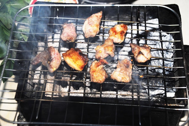 Miếng gù bò nướng trên bếp than hồng tỏa mùa thơm quyến rũ.