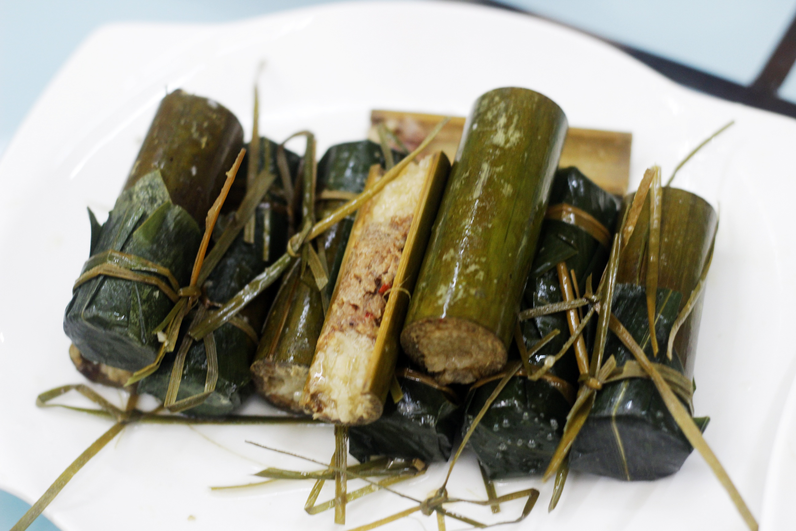 Cơm ống tre dân tộc Choang có hình dạng gần giống món cơm lam của Việt Nam, nấu bằng cách nhồi gạo thơm và thịt xay trong ống tre, nêm vừa gia vị và cho đủ nước rồi bịt kín bằng lá chuối, nướng đến khi tre chuyển màu đen. Cơm dẻo mềm, thịt thơm ngon như patê (Nguồn: Lynn Đỗ