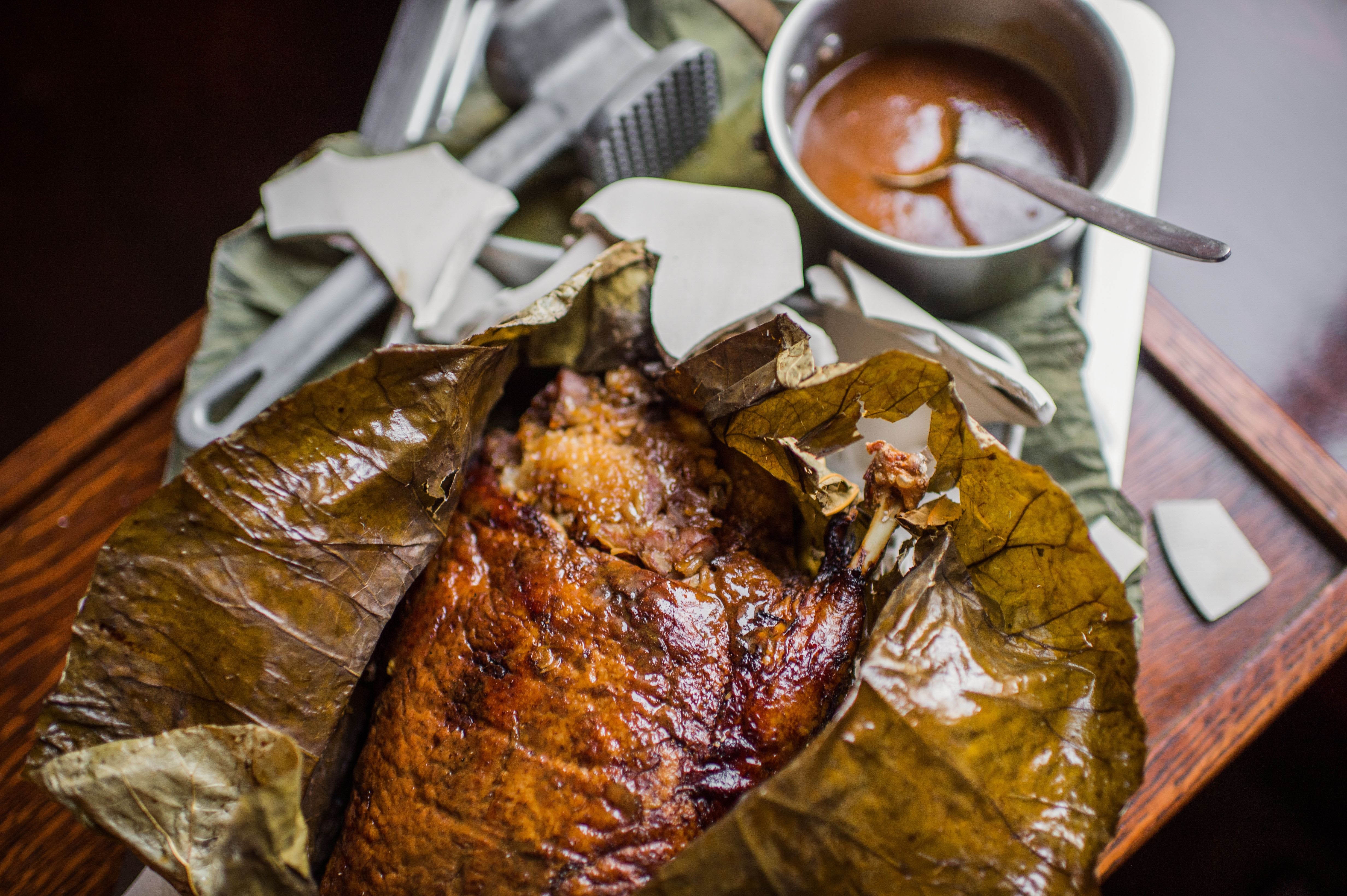 Nhồi thịt nạc lợn, măng tươi, jambon, rễ khoai sọ, nấm, đậu xanh và tôm đã được nêm nếm gia vị đặc trưng vào bên trong con vịt, bọc lá sen ở bên ngoài rồi hấp trong một thời gian dài để cho ra món ăn vịt bọc lá sen rất bổ dưỡng (Nguồn: eater.com.