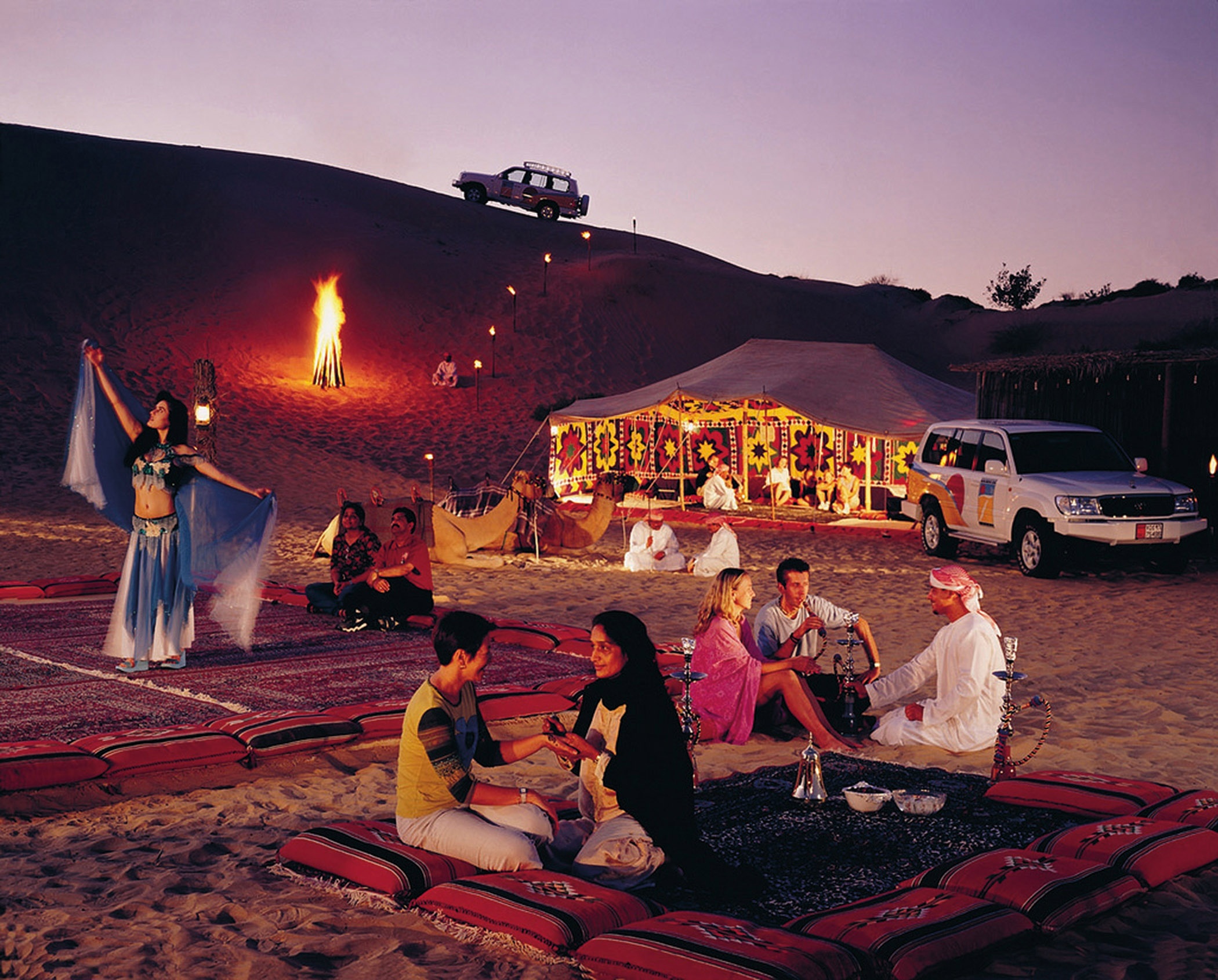 Buổi chiều bạn sẽ đi vào trung tâm của sa mạc và tham qua “Desert safari tour”, đó là trải nghiệm trên xe Land Cruiser băng qua những ngọn dốc cao vút của sa mạc, sau đó là thưởng thức tiệc đồ nướng trong những túp lều dựng bằng lá cọ khô, cưỡi lạc đà và xem những tiết mục múa bụng truyền thống. Ảnh: Jcholidays.com.au. 