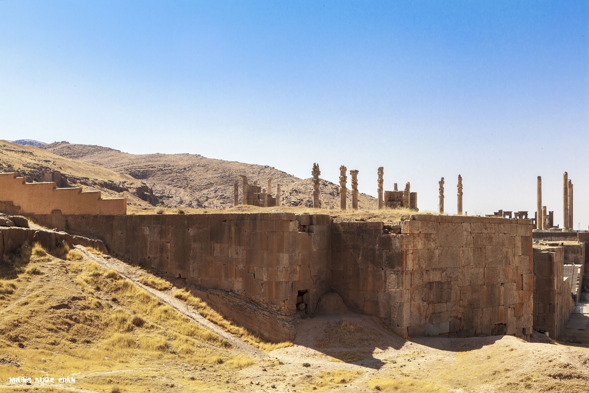 Cố đô Persepolis (515 – 331 trước công nguyên) ở Iran: Cố đô Persepolis là kinh đô nghi lễ của đế quốc Ba Tư dưới thời nhà Achaemenes tồn tại trong khoảng 690 - 328 trước công nguyên. Vương triều này còn được biết với cái tên là nhà Achaemenid. Ngày nay, Persepolis nằm cách thành phố Shiraz của tỉnh Fars khoảng 70km về phía Đông Bắc. Persepolis có nhiều công trình nguy nga, tráng lệ được điêu khắc tinh xảo bằng đá và nổi bật hơn cả là cung điện Apadana. Đại công trình này được xây dựng năm 515 trước công nguyên với chiều dài 460m, rộng 300m. Cố đô một thời oanh liệt giờ chỉ còn sót lại những cột đá ngạo nghễ, thách thức thời gian, những trụ đá cổng chào chạm khắc sắc sảo, những bức tường điêu khắc sống động... phô diễn tài năng của người thợ thủ công Ba Tư cổ đại. Ngoài tham quan các kiến trúc cổ ở Persepolis, du khách còn có thể tìm hiểu văn hóa thông qua các nghi lễ cúng tế thần linh và các lễ hội mang tính chất cộng đồng được tổ chức hàng năm tại đây.  Ảnh: Những Bước Chân.