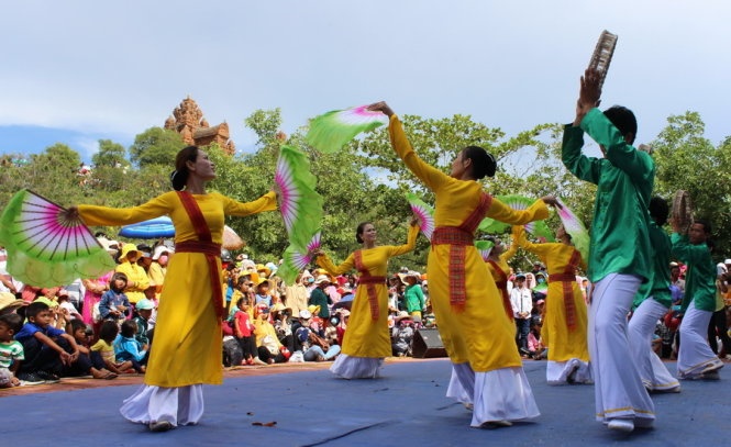 Thanh niên nam nữ Chăm múa hát mừng Katê dưới chân đồi Trầu, nơi xây dựng tháp thờ thần Po Klong Girai. Ảnh: Minh Trân.