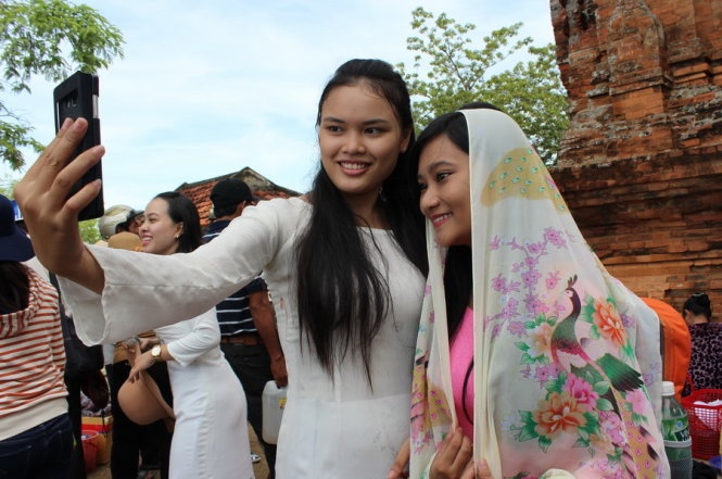 Hai du khách Chăm Lâm Nữ Tố Như (phải) và Đặng Thị Phúc Thiện đến từ xã Phan Hiệp (huyện Bắc Bình, Bình Thuận) chụp ảnh lưu niệm tại tháp Po Klong Girai trong dịp về Ninh Thuận vui đón Katê. Ảnh: Minh Trân.