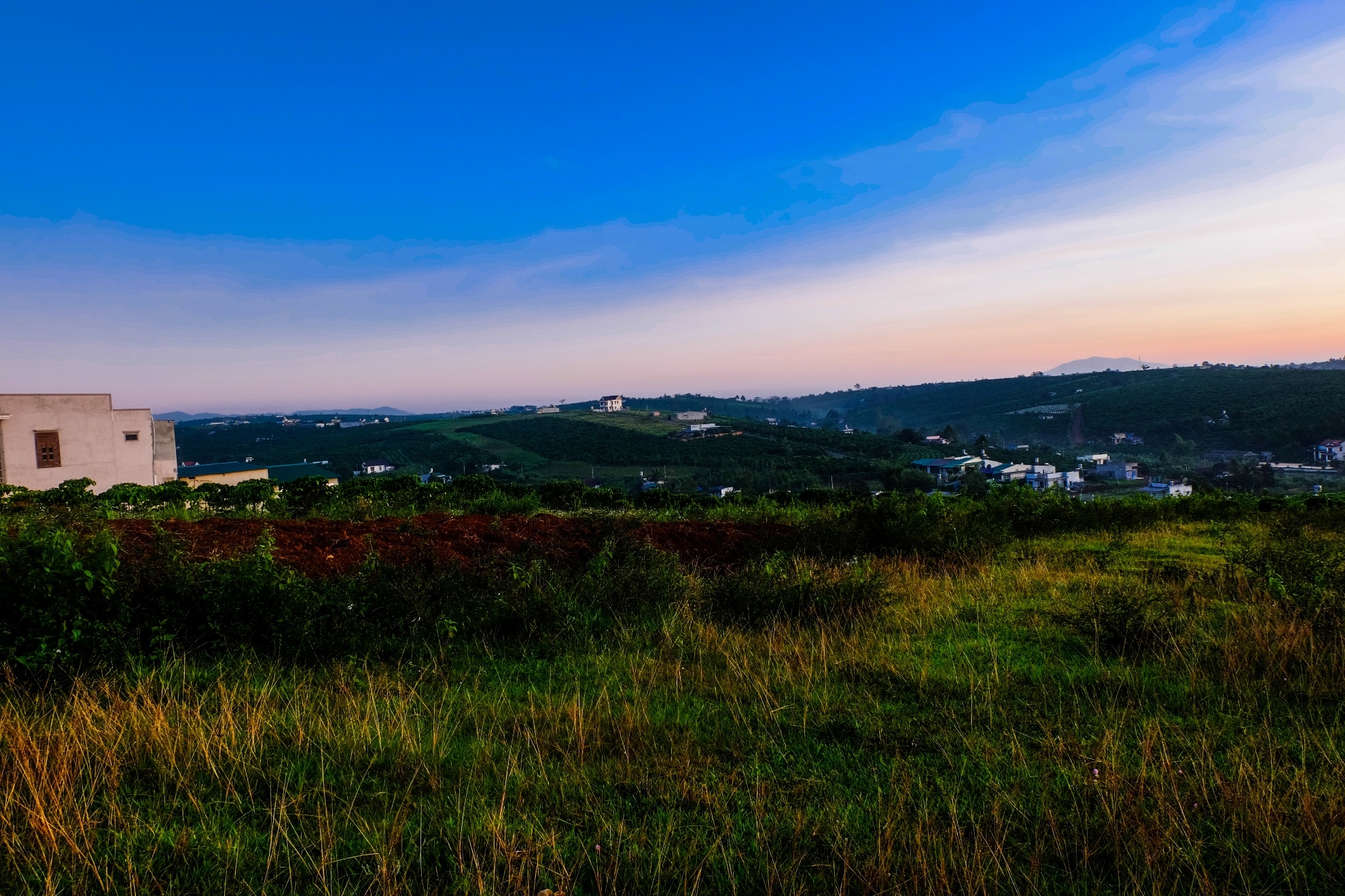 Từ trên cao nhìn xuống là những dãy đồi chập chùng nối tiếp nhau, xen kẽ vào đó là thung lũng trà và những ngôi nhà của người dân nơi đây.