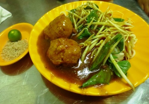 Dĩa bánh tằm được chan nước cà ri gà thêm phần thịt, mề và huyết được băm nhỏ chan lên ăn kèm với rau sống.