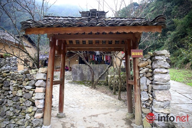 Cổng vào nhà Pao được làm bằng gỗ, chân cột và tường rào bằng đá, mái ngói âm dương phủ kín dấu vết thời gian.