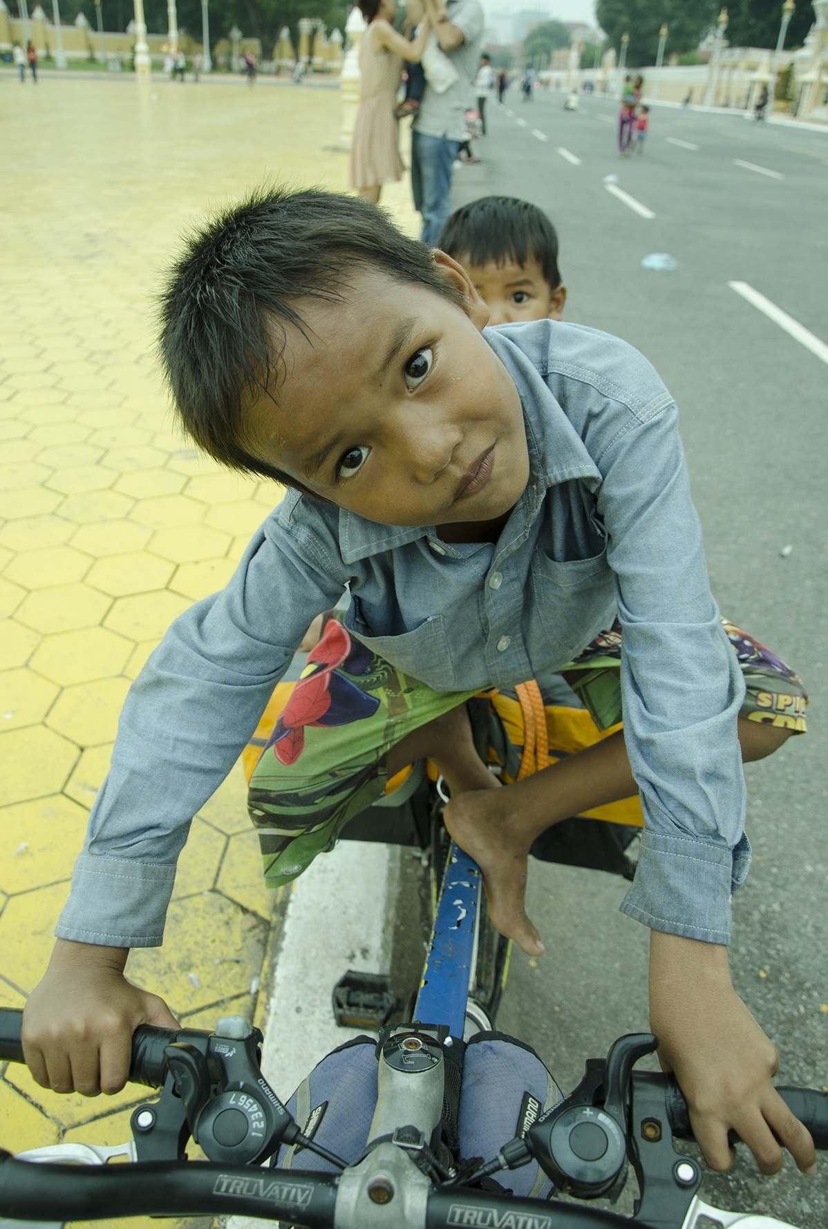 Hai đứa trẻ lang thang đùa nghịch trên chiếc xe đạp của tôi.