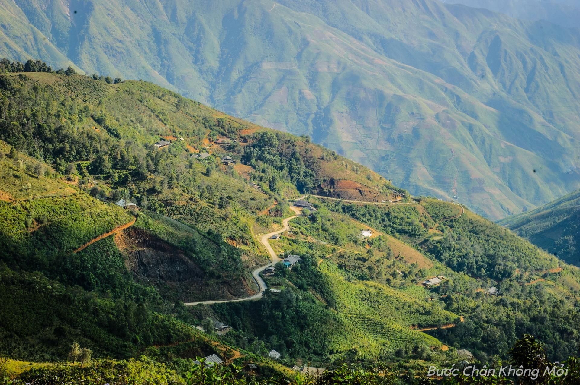 Con đường uốn lượn quanh núi và những ngôi nhà của người Mông thấp thoáng giữa rừng, tô sắc thêm cho khung cảnh Tây Bắc tuyệt đẹp.