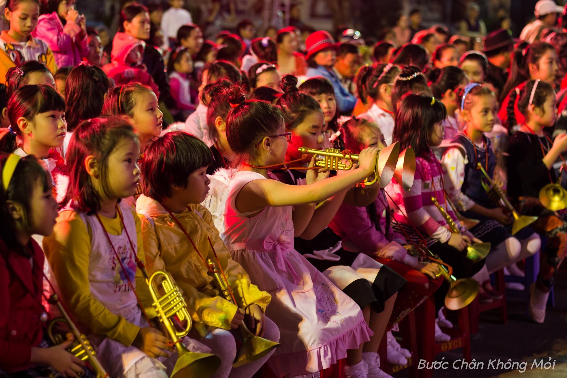 Những em bé Thiên Thần với đôi cánh trắng sau lưng cùng chiếc kèn vàng đang ngồi chờ đợi đến lượt mình lên diễn. 