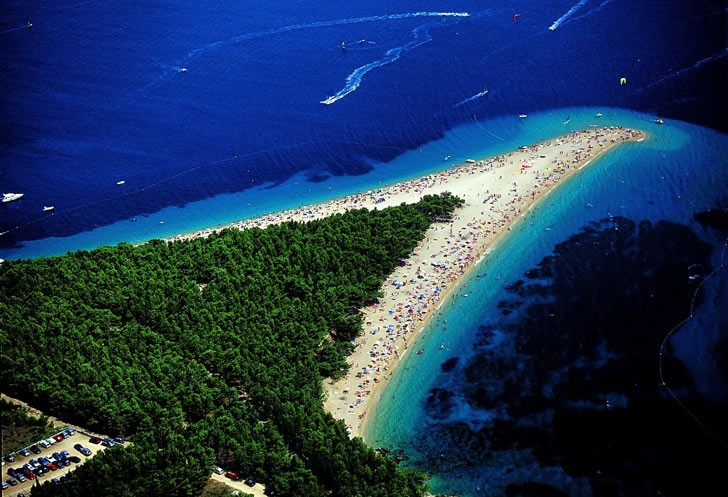 Zlatni Rat, Croatia: Bãi biển nằm gần thành phố Bol ở phía nam của đảo Brac nên nơi đây có một phần bị thu hẹp với bãi biển cát vàng, sỏi trắng và bao quanh là rừng thông xanh mướt. Những đợt thủy triều thay đổi thất thường mang theo những dòng chảy của biển và gió nên đã tạo ra những hình thù khác nhau cho bãi biển này. Tùy theo hướng gió thay đổi, Zlatni Rat có thể uốn lại thành hình móc câu, lúc như chiếc mũi, có khi lại thành cái lưỡi rất độc đáo.