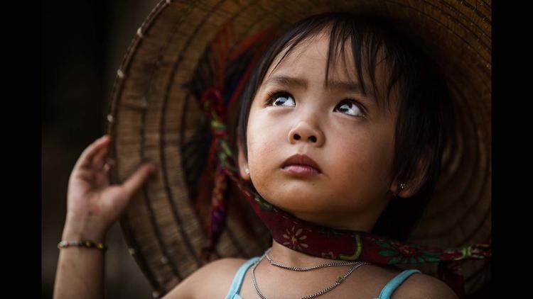 Tuyết, bé gái 4 tuổi sống ở Điện Biên Phủ đang ngước nhìn mẹ.