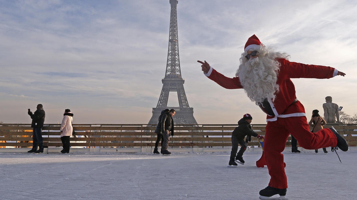 Santa Claus trượt băng tạo dáng trước tháp Eiffel, Paris (Ảnh: Jacky Naegelen)
