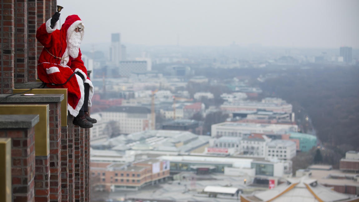 Ông già Noel tạo dáng vắt vẻo bên ngoài tòa tháp Kollhoff ở quảng trường Potsdamer Platz, Berlin. (Ảnh: Hannibal Hanschke)