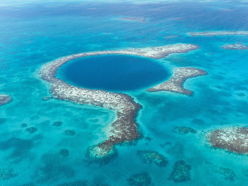 Hố đại dương rộng nhất thế giới - The Great Blue Hole, Belize: Great Blue Hole rộng gần 304 m, sâu 122 m. Hố có vách đá ngầm phát sáng nhờ cát và san hô, trong khi nước màu xanh thẫm.