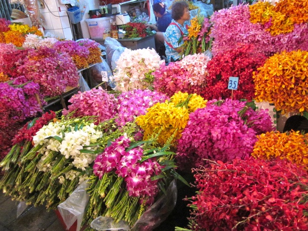 Chak Phet Road và chợ hoa Pak Khlong Talad Đây là chợ hoa ngoài trời rất lớn ở Bangkok, và Thái Lan nổi tiếng với hơn 30.000 loài hoa lan. Từ Pahurat bạn có thể đi bộ đến chợ hoa để có dịp chiêm ngưỡng cả chục ngàn loài hoa, từ những loại lan quý hiếm đến cẩm chướng, tre trúc, hoa súng, hay những bông hồng tươi rói mới cắt được cuốn trong giấy báo. Thời điểm lý tưởng nhất đến thăm chợ hoa là vào sáng sớm, khi những người thợ tất bận chuẩn bị hoa trang trí cho các bàn thờ trong chùa, nhà hàng, đám cưới, sảnh khách sạn, kể cả những dây hoa xinh xinh treo trong taxi để lấy may. Bạn có thể ăn sáng với món dumpling hoặc bánh bao. Khu chợ đầy màu sắc này là điểm đến yêu thích của nhiều nhà nhiếp ảnh.