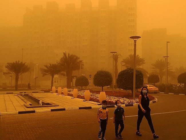 Người dân đeo khẩu trang kín mít khi ra đường. Các tòa nhà mờ mịt trong cát. Dự báo trong cuối tuần, gió vẫn tiếp tục mạnh.