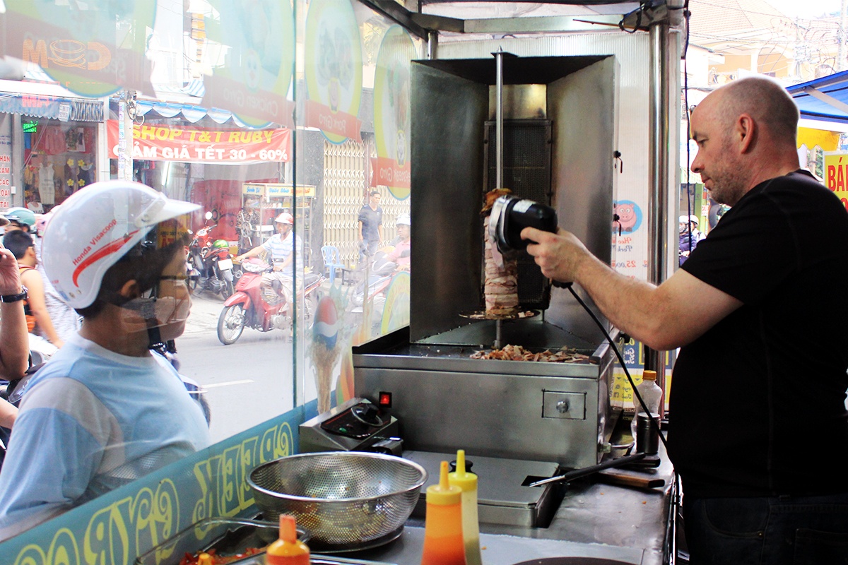 Không chỉ thu hút bởi tủ hàng bắt mắt, tên món mới lạ, quán còn khiến người đi đường phải “ngoái nhìn” bởi hình ảnh anh chủ quán, khiêm bếp trưởng Tây của quán bánh mì lề đường gần chợ Hoàng Hoa Thám, đoạn gần ngã tư Cộng Hòa - Hoàng Hoa Thám, Tân Bình.