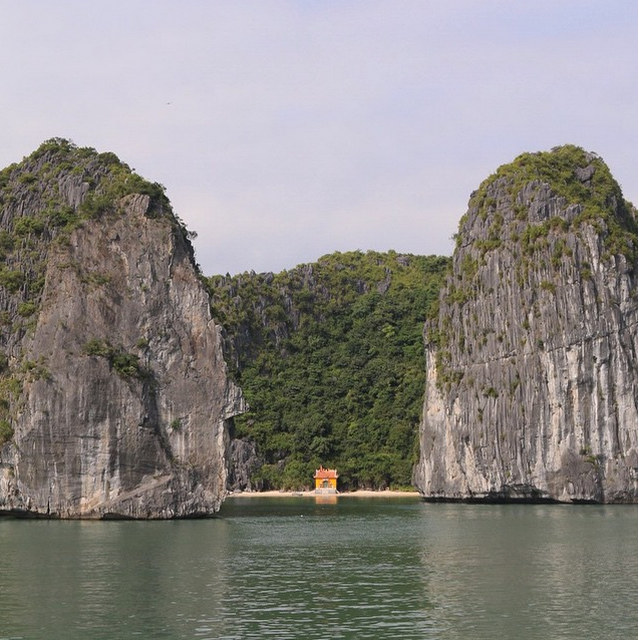 Một ngôi đền đơn độc bên bãi biển, bao quanh là những núi đá vôi tại Hạ Long.