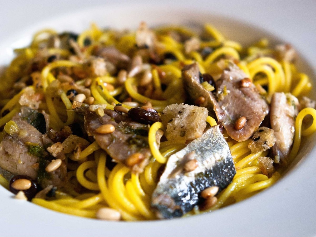 Món con le sarde ở Sicily dùng loại mì gần giống spaghetti nấu cùng cá mòi, hạt thông, bơ và dầu ô liu.