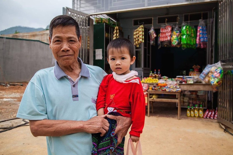 Hai ông cháu ở cửa hàng tạp hóa, thị trấn Đồng Văn: Tôi chưa bao giờ làm nhiều người lớn cười và nhiều trẻ con khóc đến thế (đôi khi cùng lúc) như tôi làm ở Hà Giang. Nhiều người dân ở đây như rất hiếm khi thấy người nước ngoài. Vùng này còn mới đối với du lịch nên ít người đến đây. Du lịch bắt đầu manh nha từ cuối những năm 2000. Đến năm 2015, mọi thứ thay đổi rất nhanh chóng.