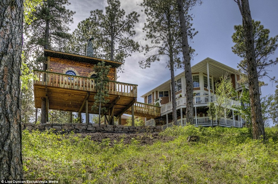 Căn nhà trên cây này là một phần của gói dịch vụ khi du khách thuê dinh thự Chateau de Soleil (bên phải) ở South Dakota.